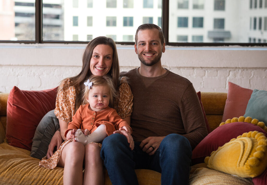 Dr. Fischman, his wife, and their little girl getting a family photo taken on a couch