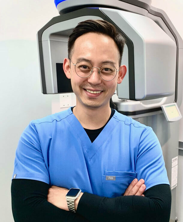 Team member Eugene of Nebraska Dental Center standing in front of x-ray machine
