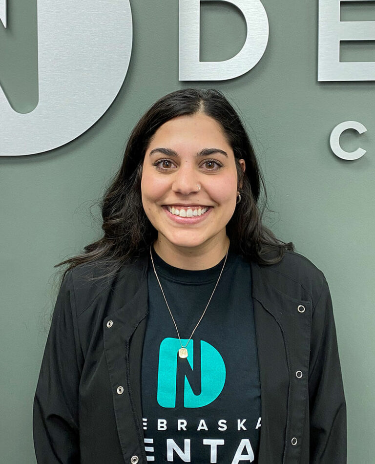 team member dana standing in front of logo